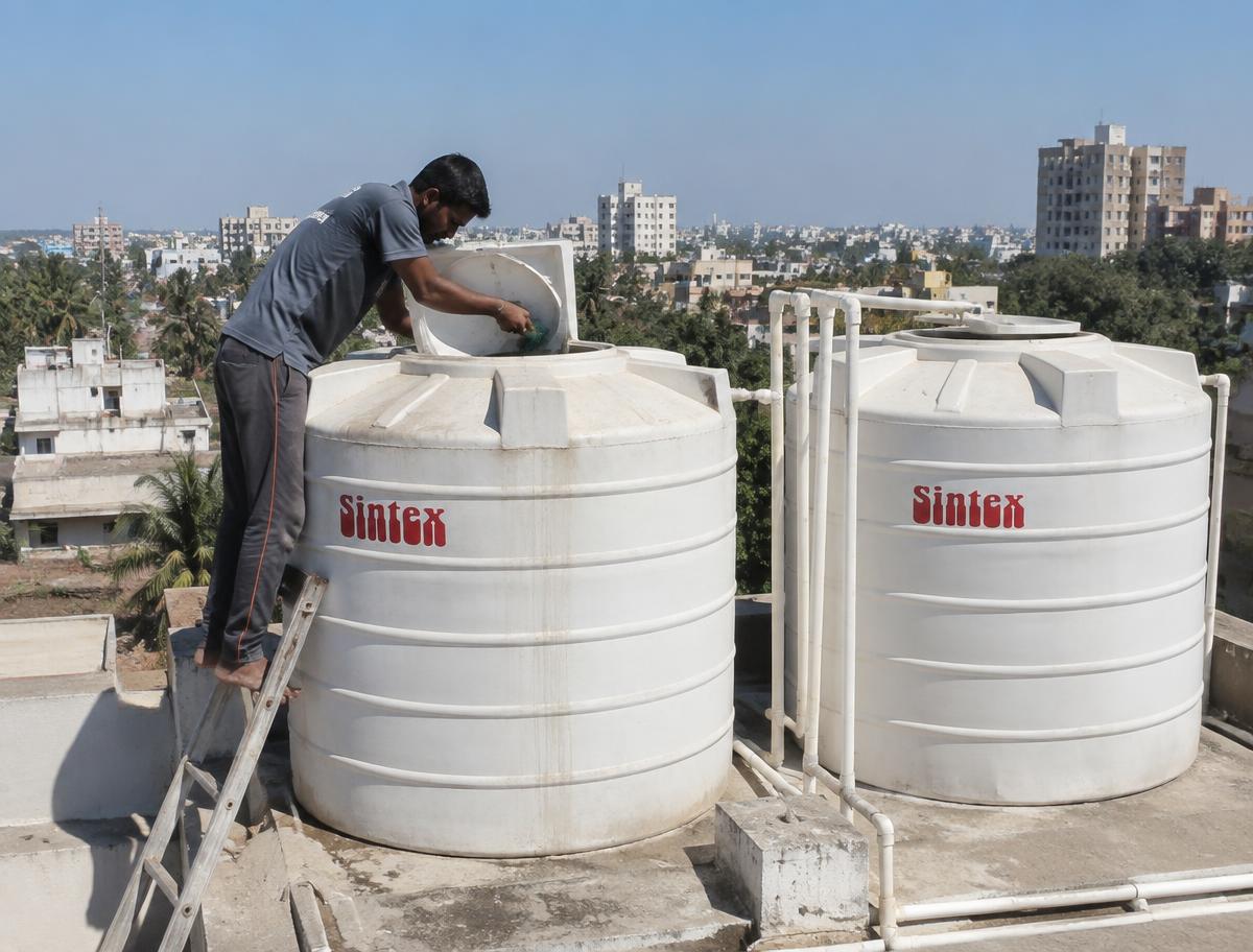 Technician cleaning rooftop water tanks in Bangalore